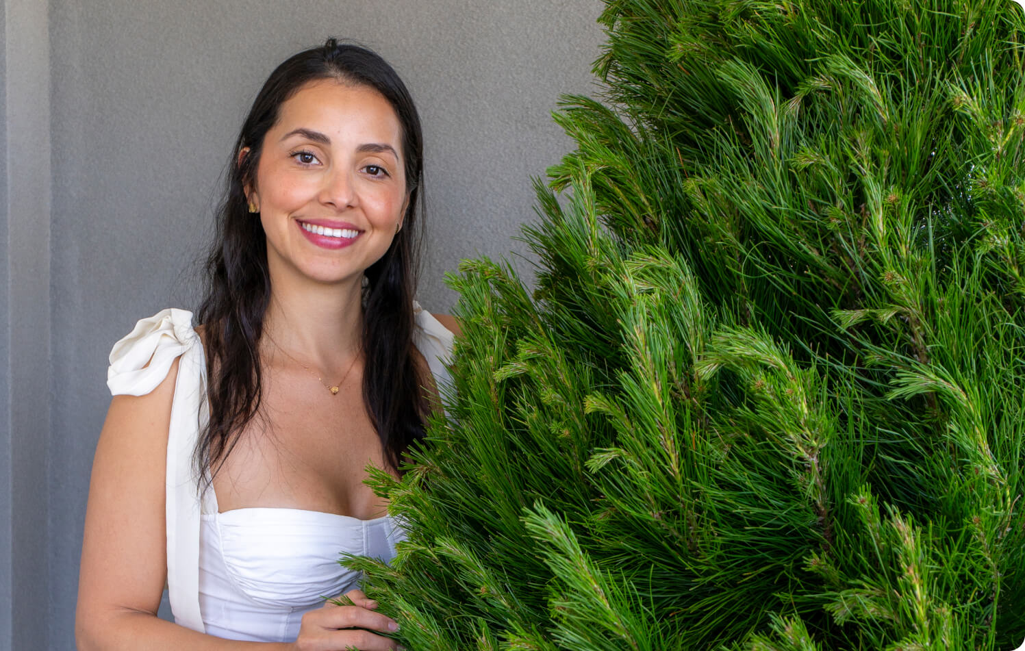 Customer support lady standing next to Christmas Tree