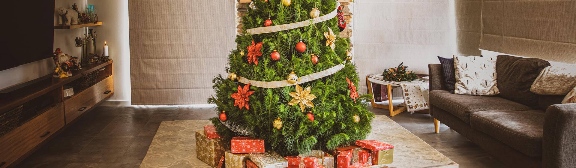 Photo of decorated Christmas tree in a family lounge room with presents underneath