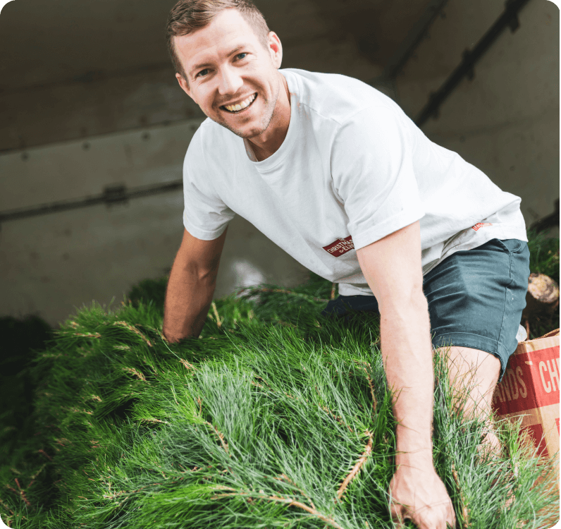 Image of The Tree Elves co-founder Jeremy taking a tree out of the delivery truck.